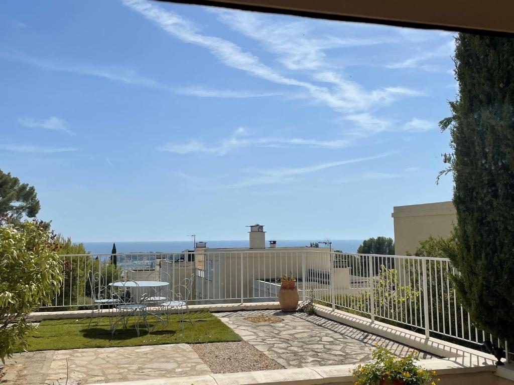 uma vista para um pátio com uma cerca branca em Appartement de caractère vue mer panoramique em Bandol