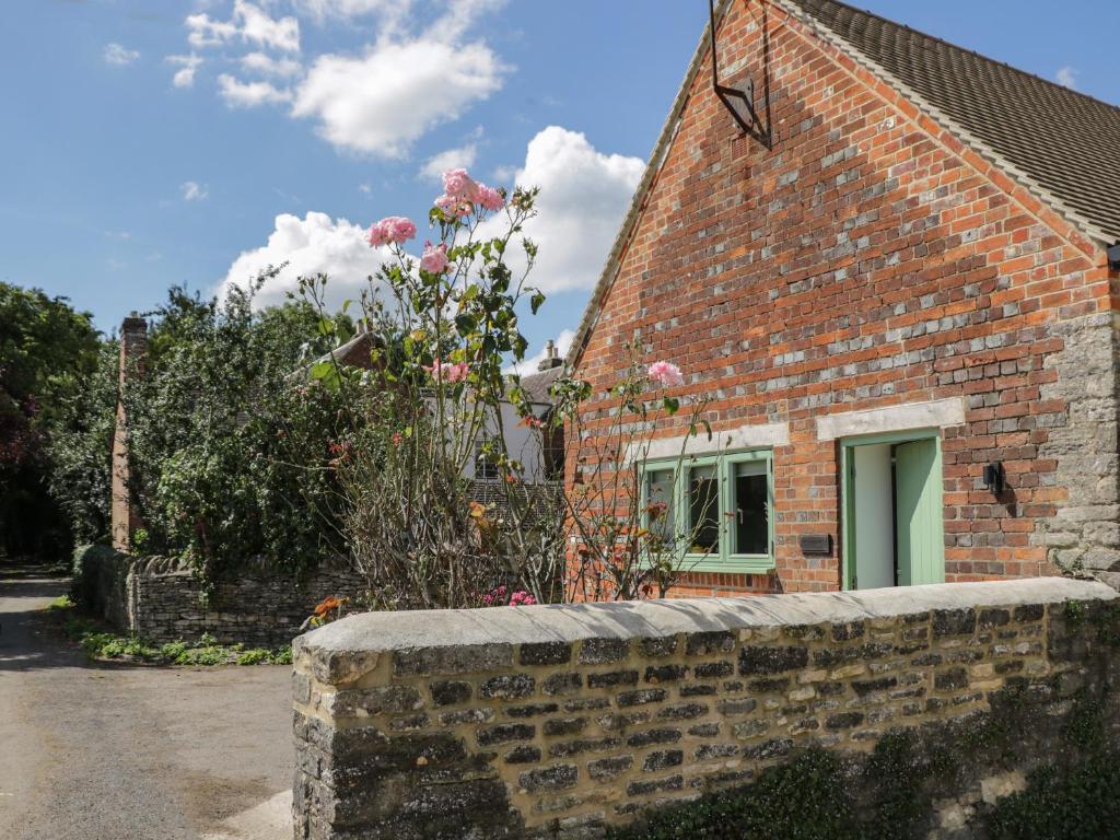 a brick house with a window and a brick wall at The Office in Witney