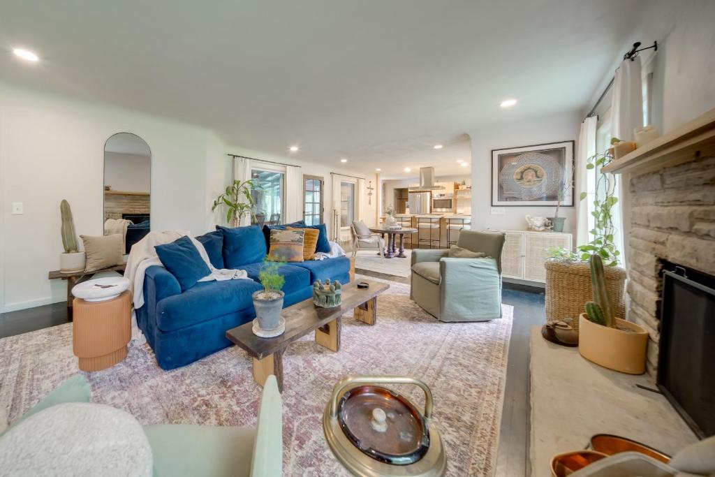 a living room with a blue couch and a fireplace at Stylish Willoughby Hills Retreat with Fireplace! 