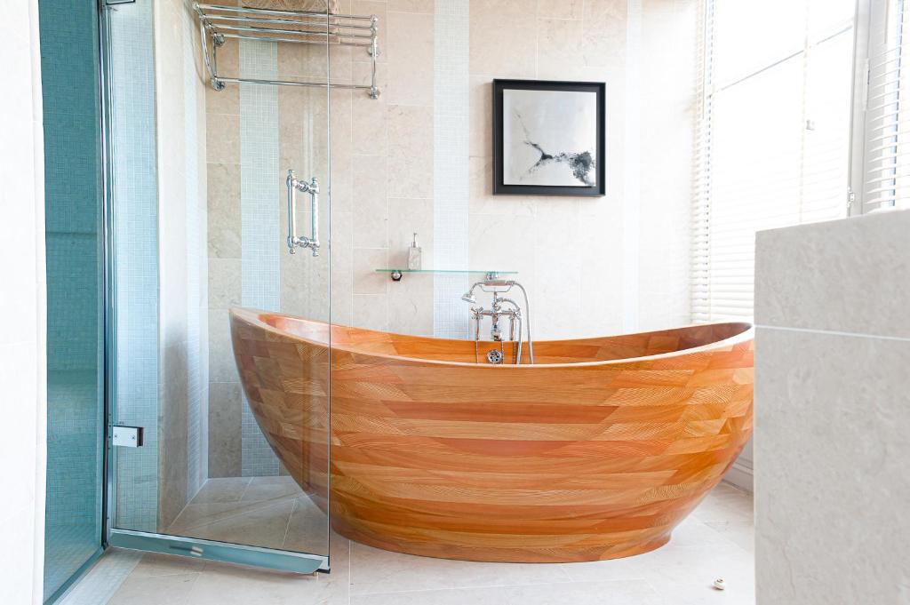 a wooden tub in a bathroom with a shower at Chambres d'Hôtes Eden Ouest in La Rochelle