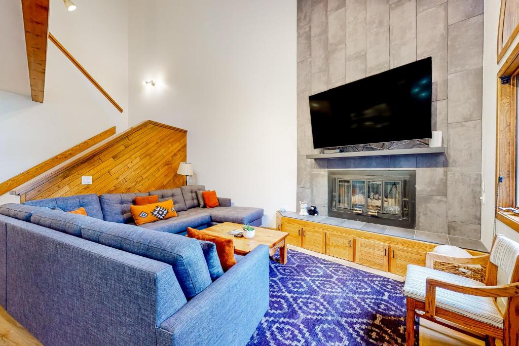 a living room with blue couches and a fireplace at King's Crown in Breckenridge