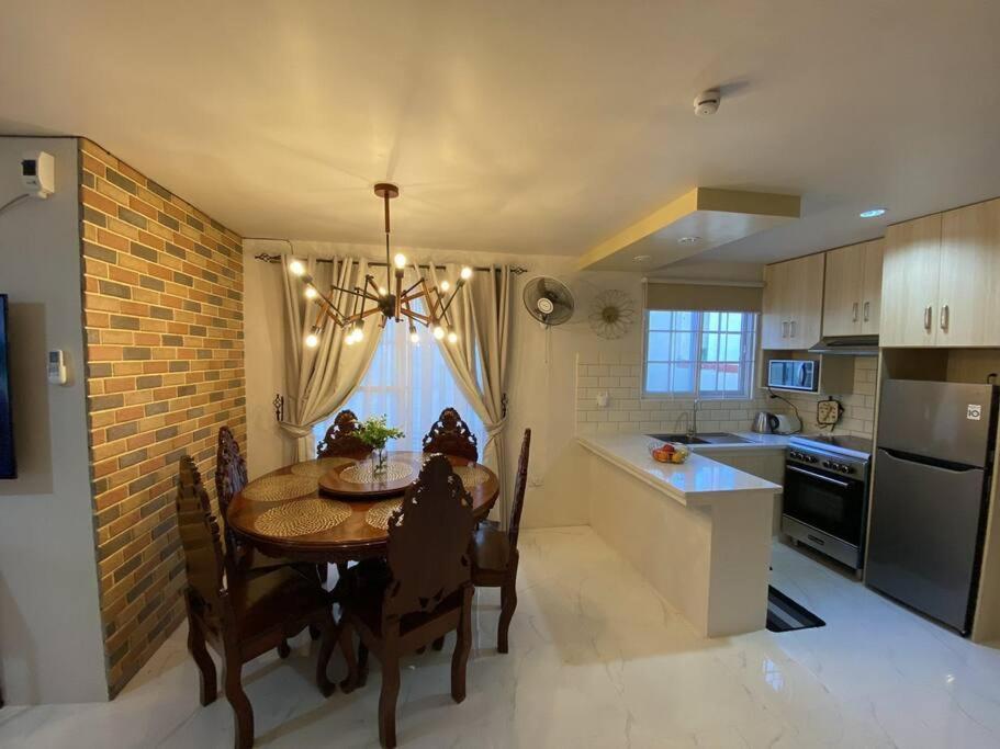une cuisine avec une table et une salle à manger dans l'établissement Hillside Homestay Subic-Fully Furnished House 3BR, à Subic
