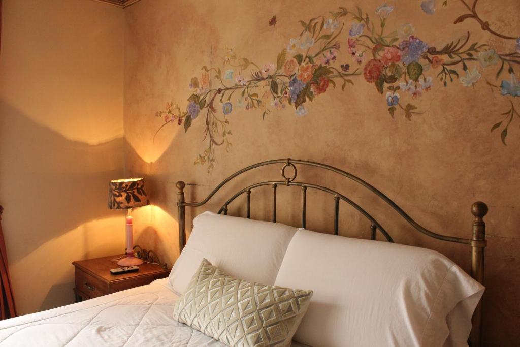 a bedroom with a bed with a flower mural on the wall at Hotel Ines Maria in Cuenca