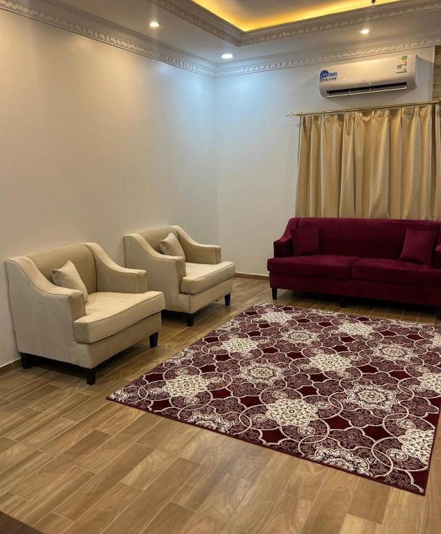 a living room with two couches and a rug at أحلى الليالي للشقق الفندقية in Yanbu