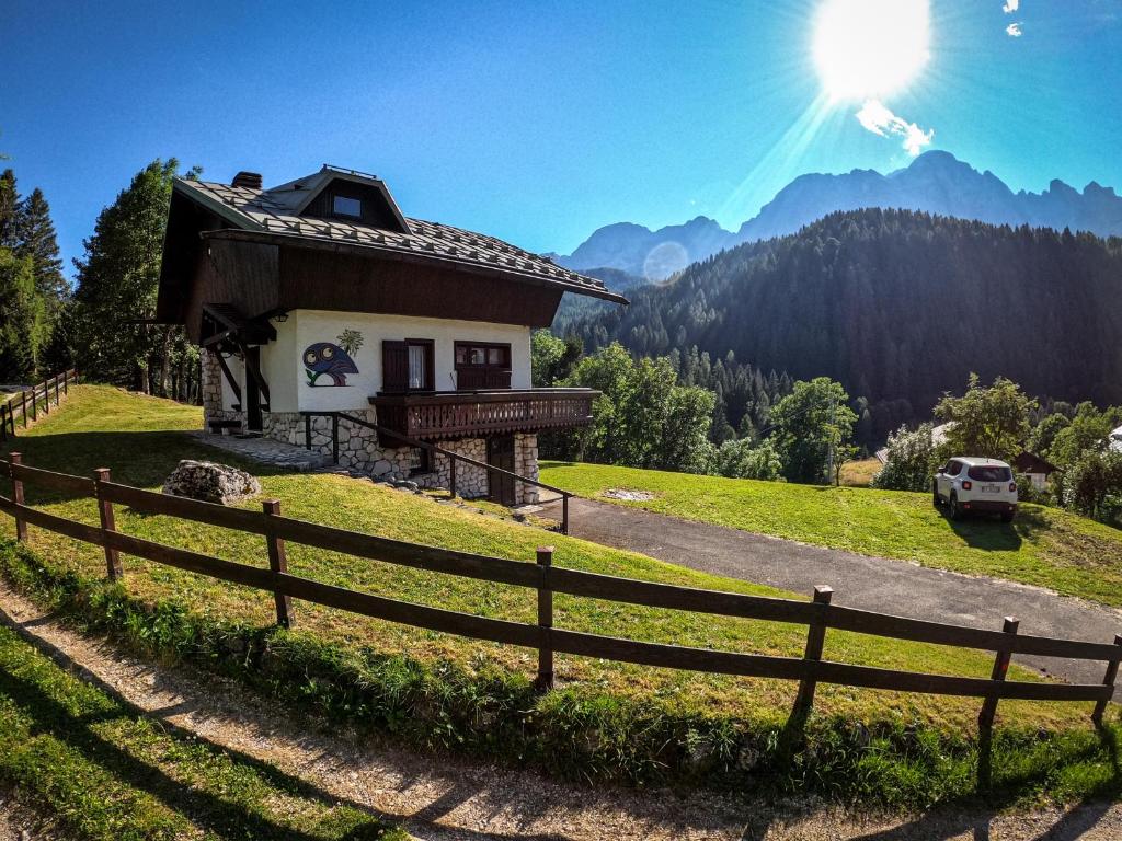 een klein huis op een heuvel met een hek bij Chalet della Civetta 