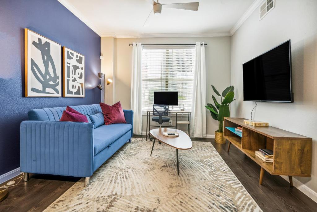 a living room with a blue couch and a tv at 1001 Ross Avenue in Dallas