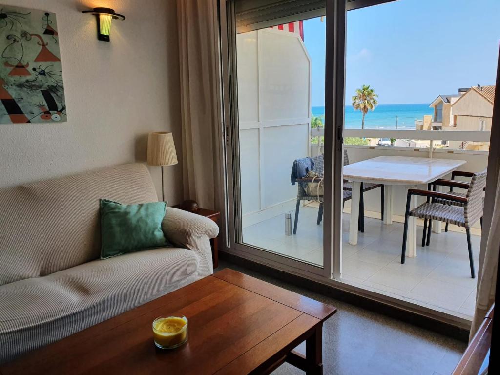 - un salon avec un canapé et une vue sur l'océan dans l'établissement apartamento con vistas al mar a pocos metros de la playa, à Valence