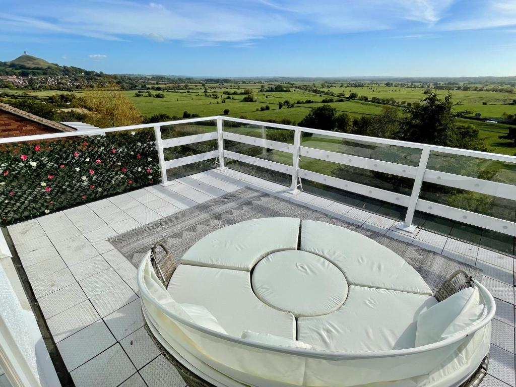 a white tub on a balcony with a view at Magic of Avalon in Glastonbury