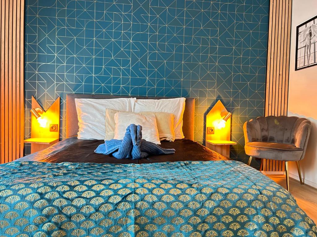 a bedroom with a bed with a blue wall at Les 6 reflets du lac in Torcy