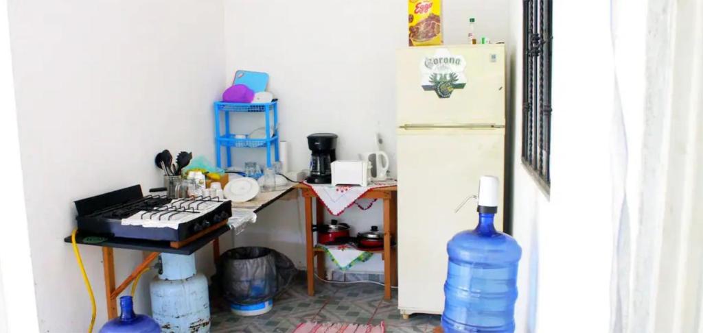 uma cozinha com um frigorífico e uma mesa com um fogão em Chentes Place em Barra de la Cruz