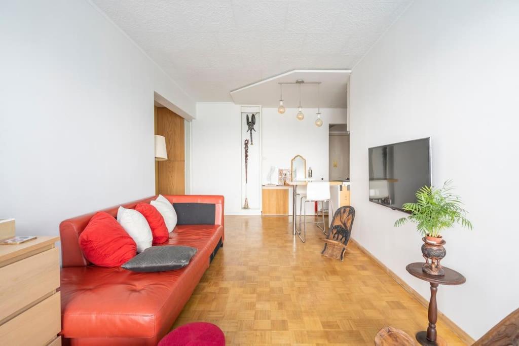 a living room with a red couch and a television at A 3 km du centre ville in Brussels