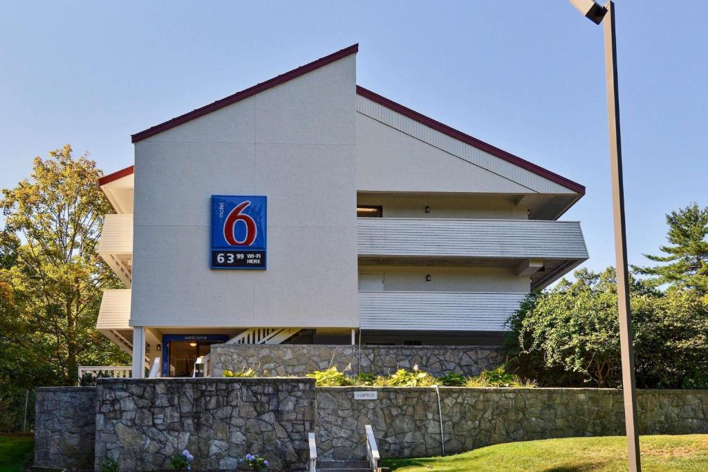 un bâtiment avec un panneau sur son côté dans l'établissement Motel 6-Nashua, NH - South, à Nashua