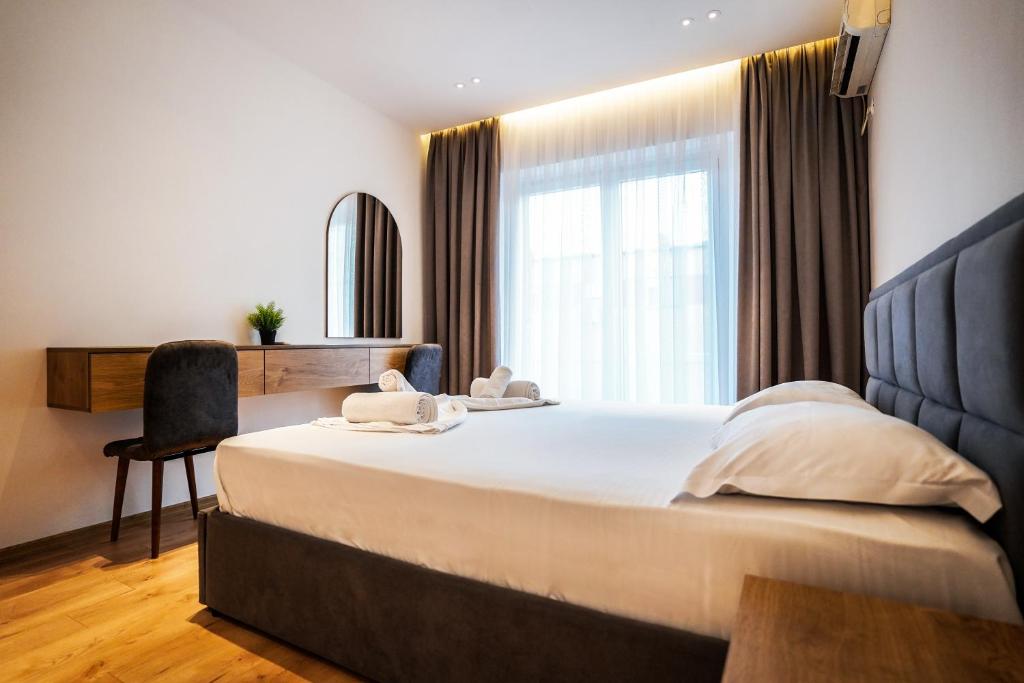 a bedroom with a large bed and a window at 2BR at Café Flora - Skanderbeg Square Area in Tirana
