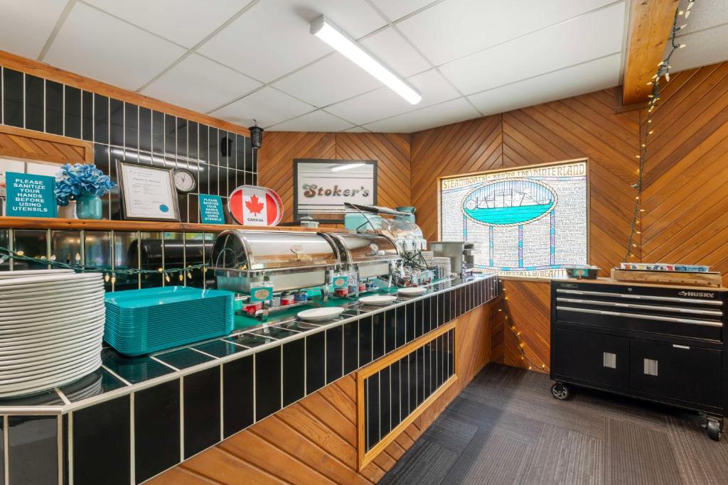 a kitchen with a counter with plates and dishes at Stoke Hotel SureStay Collection by Best Western in Revelstoke