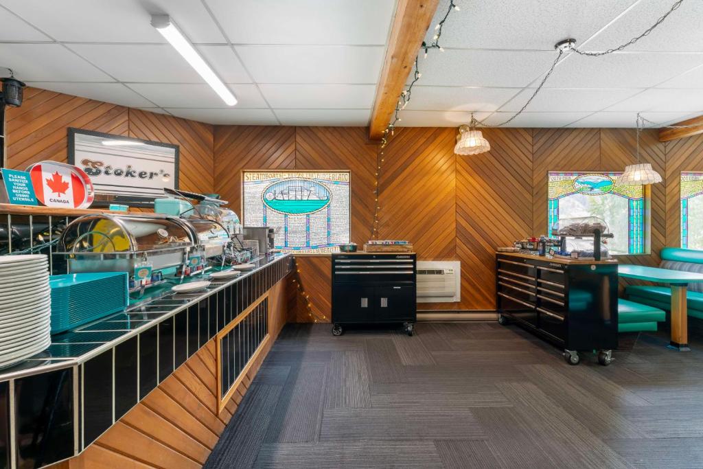 a restaurant with wood paneled walls and a counter at Stoke Hotel SureStay Collection by Best Western in Revelstoke