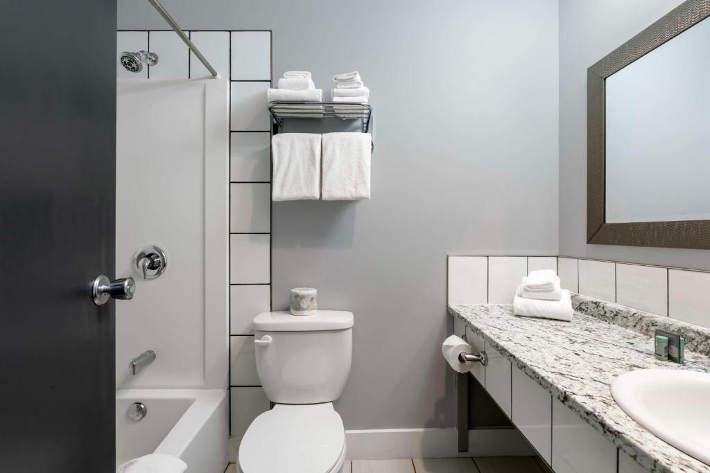 a bathroom with a toilet and a sink and a mirror at Stoke Hotel SureStay Collection by Best Western in Revelstoke