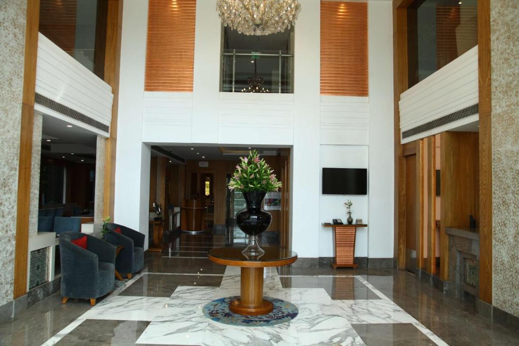 a lobby with a vase with a plant on a table at The Place Gurugram, a member of Radisson Individuals in Gurgaon