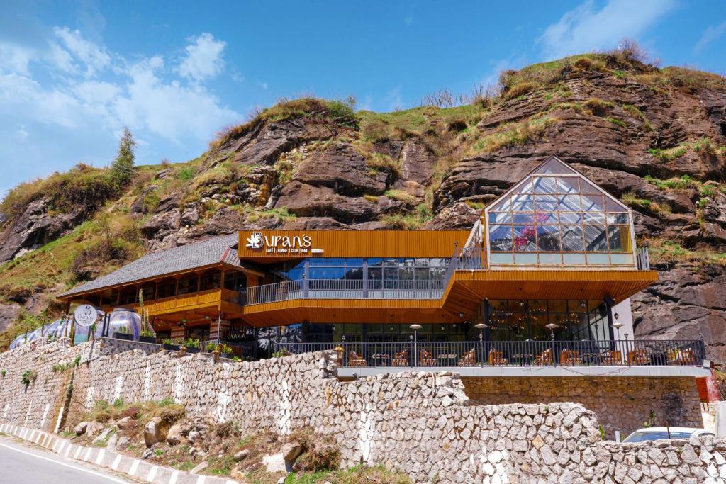 a building on the side of a mountain at Palchan Hotel & Spa - A member of Radisson Individuals Retreats in Manāli