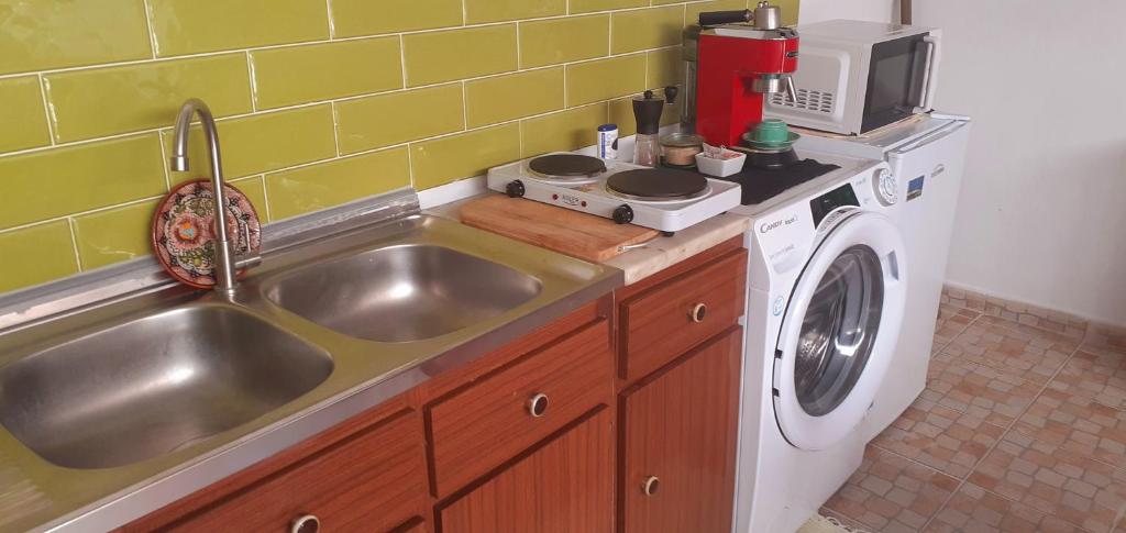 a kitchen with a sink and a washing machine at Cantinho dos moinhos in Figueira da Foz