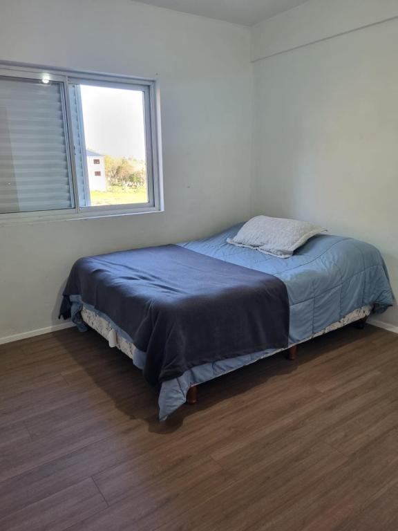 Bett in einem weißen Zimmer mit Fenster in der Unterkunft Mitre 1400 Apartamentos in Monte Grande