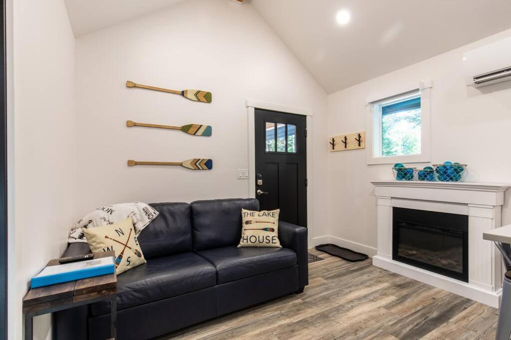 a living room with a black couch and a fireplace at Lake House tiny cabin near Lake Wenatchee in Leavenworth