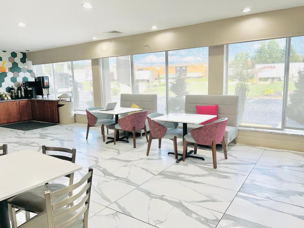 a dining room with tables and chairs and windows at Quality Inn & Suites McDonough South I-75 in McDonough