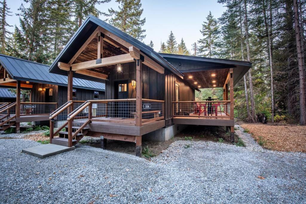 uma cabana de madeira com um grande deque na floresta em Ski Chalet A cozy little cabin in the woods near Lake Wenatchee em Leavenworth