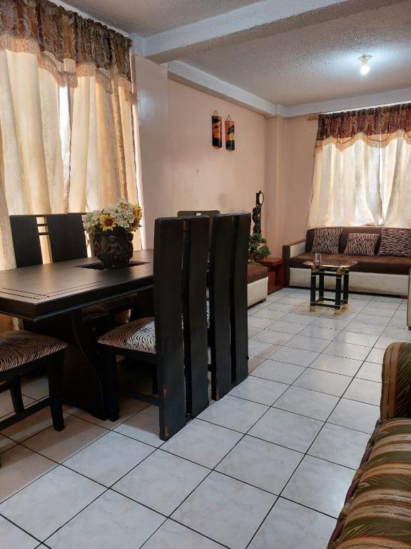 a waiting room with a table and chairs and curtains at Acogedor departamento in Loja