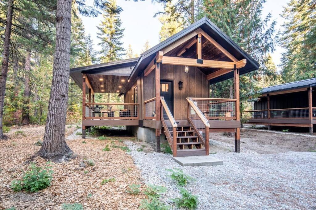 a large wooden cabin in the woods with a staircase at Bear Den a Cozy 1 Bedroom tiny Cabin near Lake Wenatchee in Leavenworth