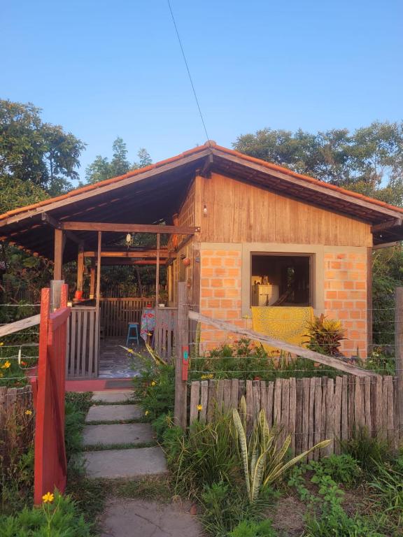 una pequeña casa con una valla delante de ella en Hospedagem Casinha do Solar, en Soure
