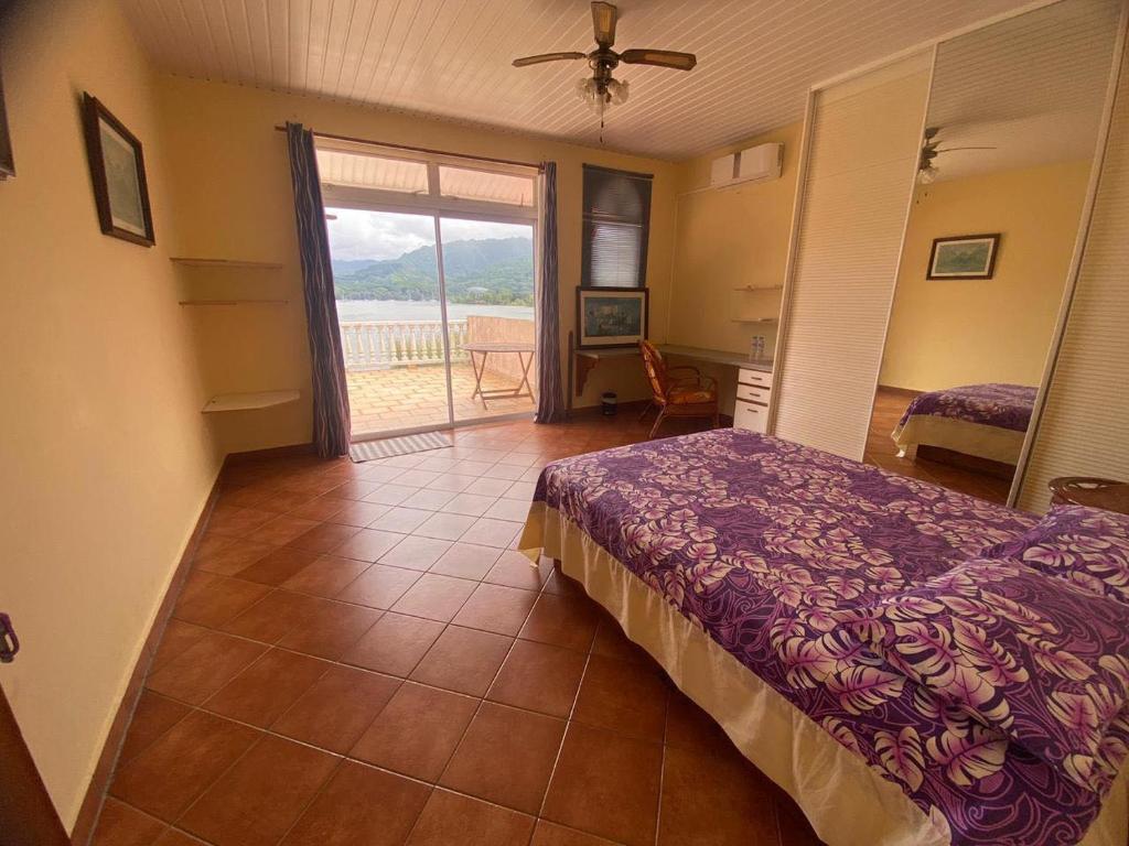 una camera con letto e porta di accesso a un balcone di Te Mana Lodge a Taravao