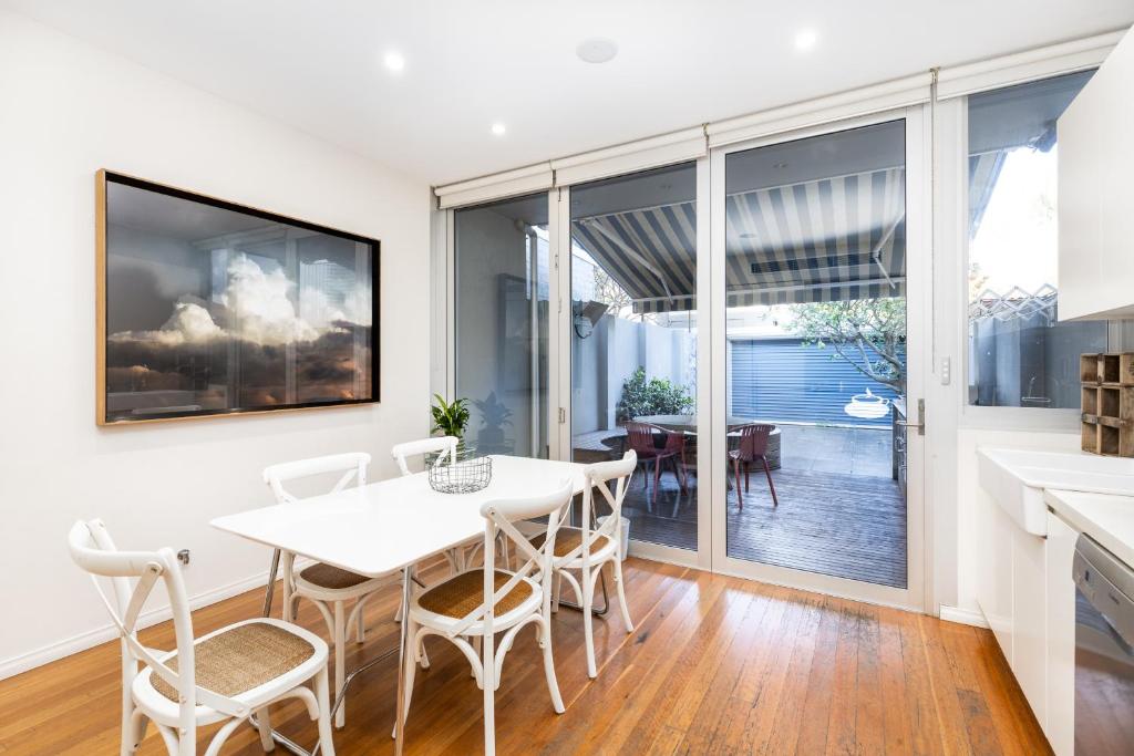 a kitchen and dining room with a white table and chairs at Surry Hills Terrace in Sydney