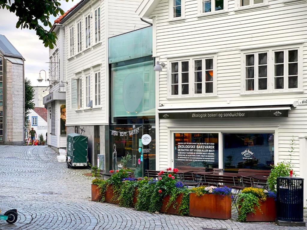 a store on a street next to a building at Charming Rooftop Apartment in Heart of Stavanger in Stavanger