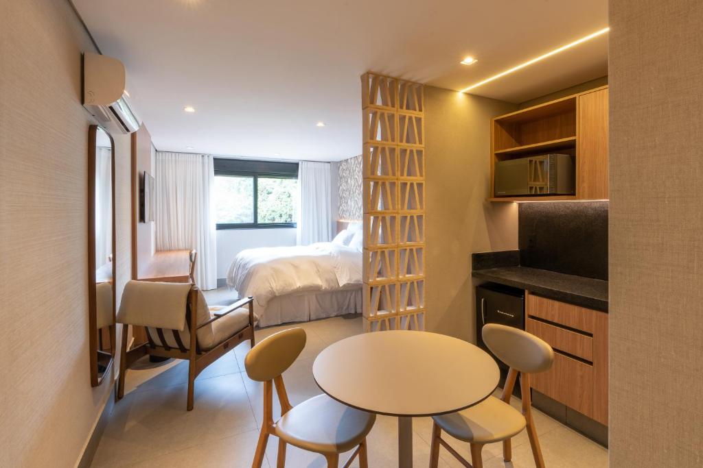 アウト・パライーゾ・デ・ゴイアスにあるPousada Flor de Anisのベッド、テーブル、椅子が備わる小さな客室です。