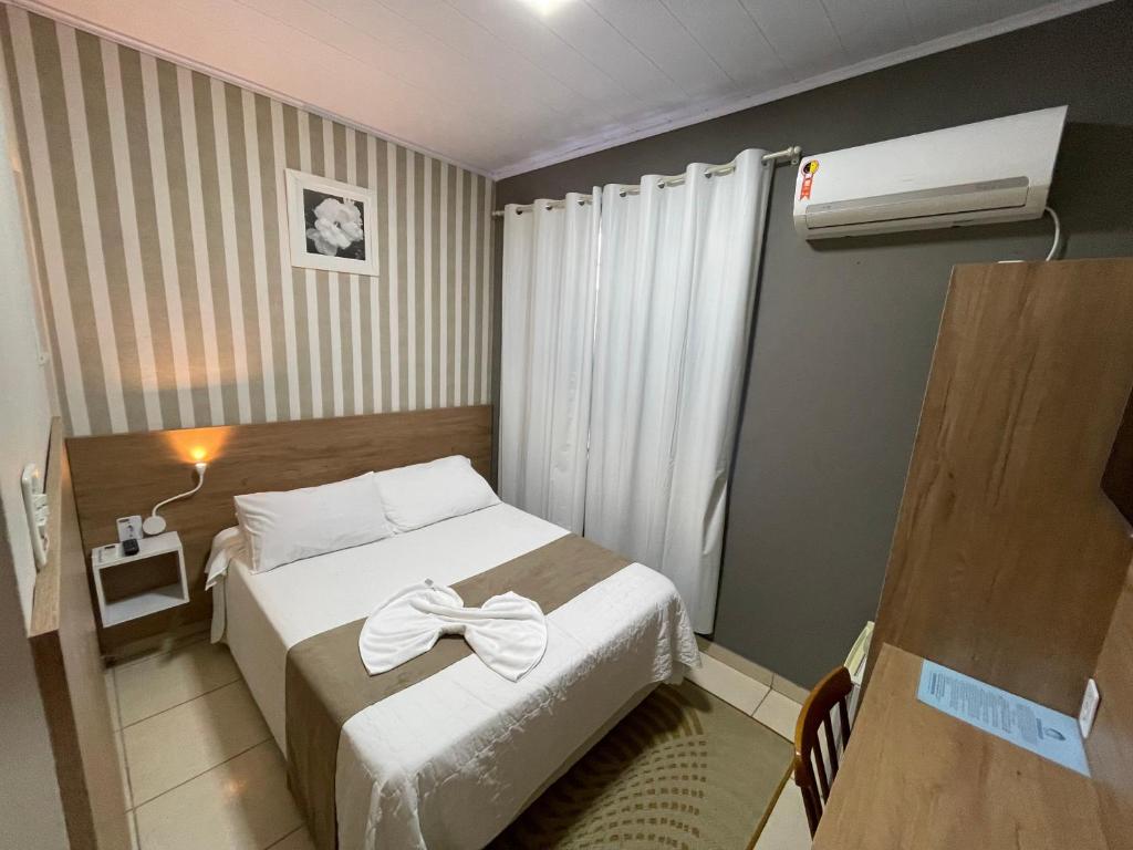 a small room with a bed and a air conditioner at Hospedar Flats & Residence in Santa Cruz do Sul
