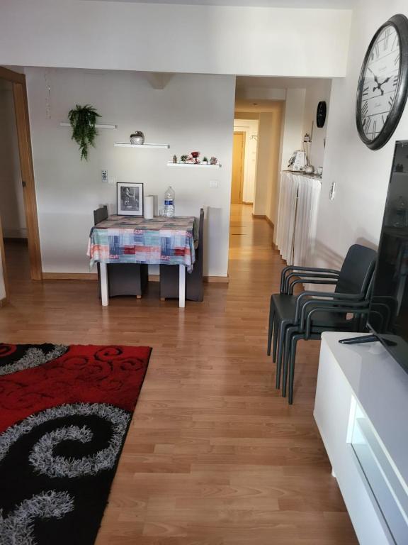 a living room with a table and chairs and a clock at holiday hogar altea in Altea