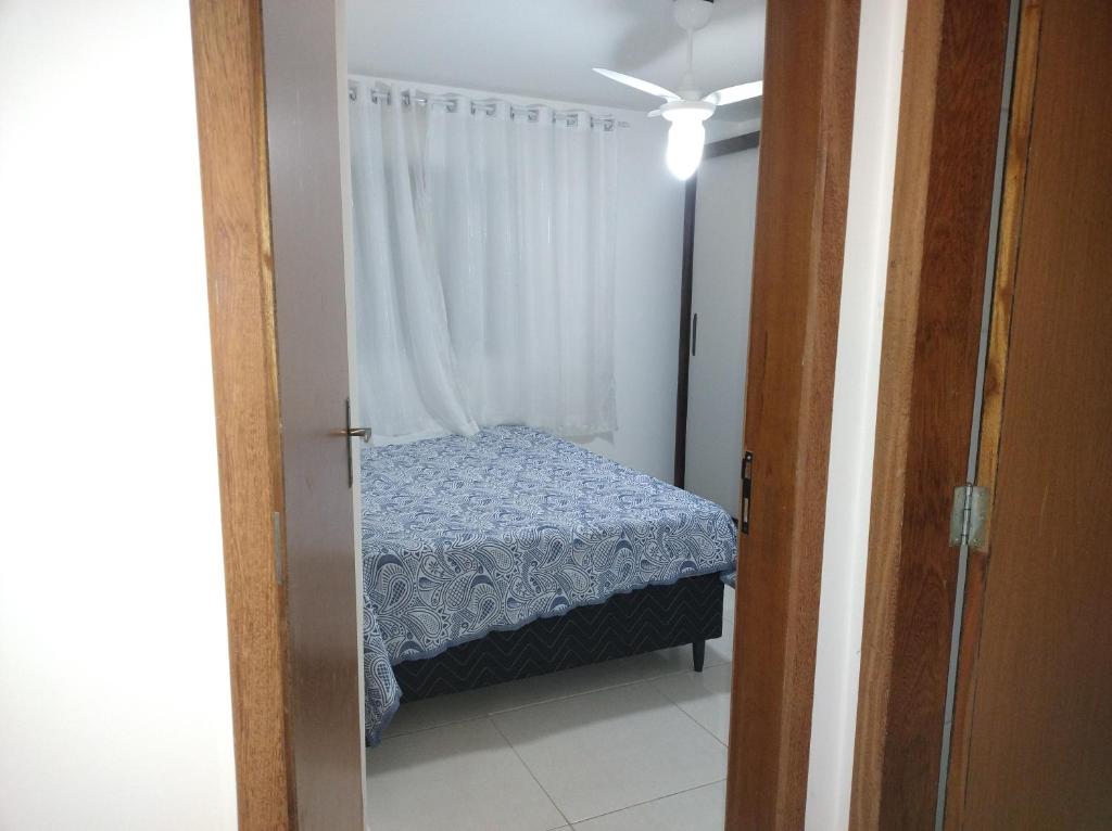 um pequeno quarto com uma cama com uma cortina em Casa da Bia apto 01 - apto inteiro em Vila Velha