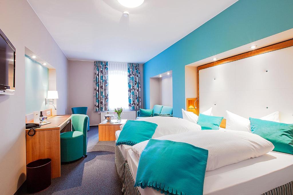 カウフボイレンにあるホテル アム トゥルムのベッド2台とデスクが備わるホテルルームです。