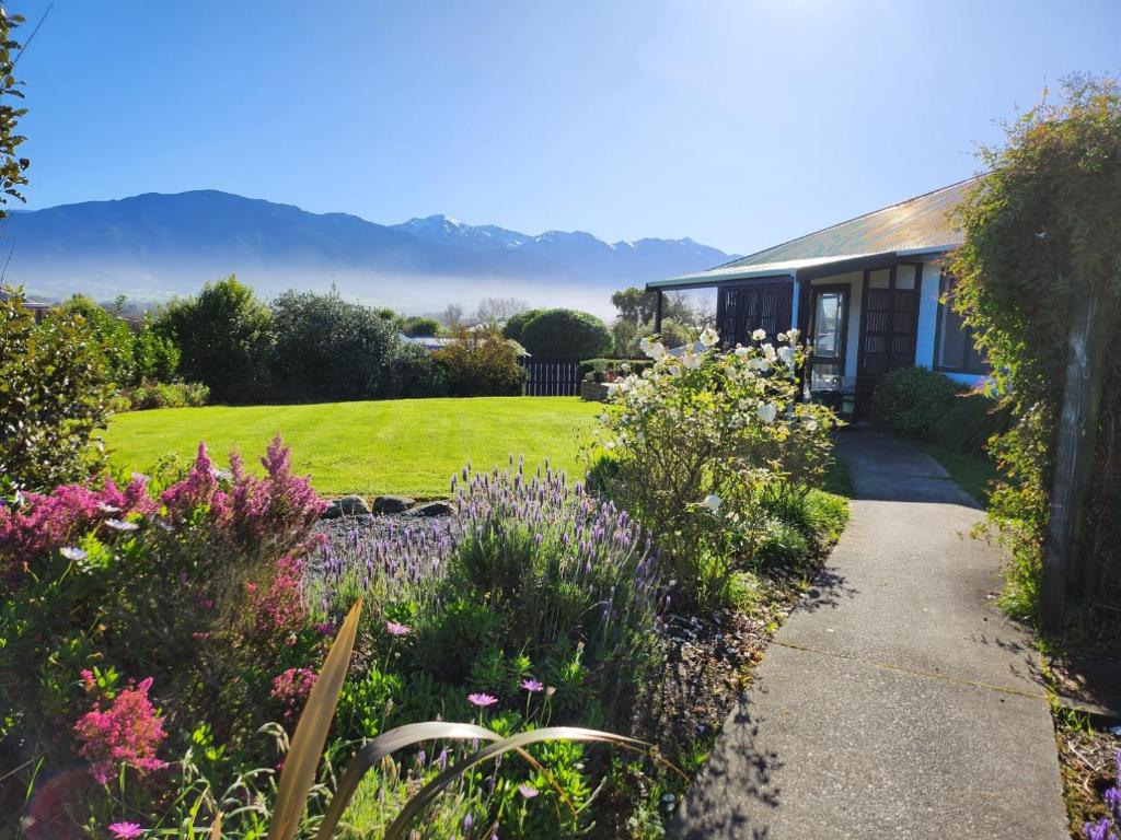 a house with a garden with flowers in front of it at Mountainview in Kaikoura