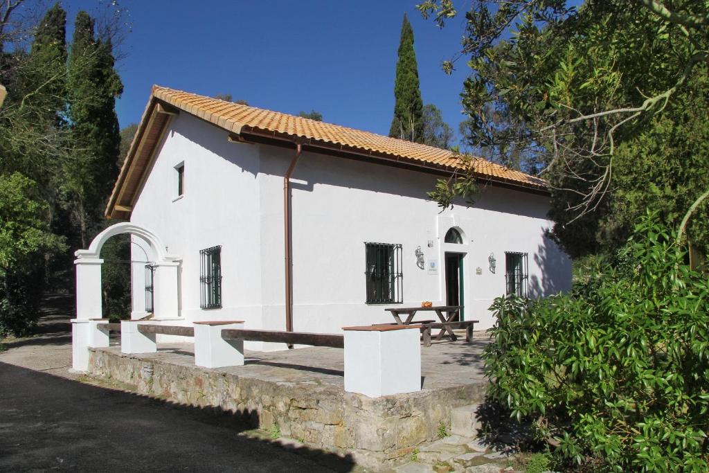 a white house with a picnic table in front of it at Complejo Rural Huerta Grande in Algeciras