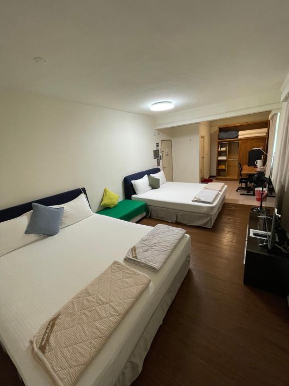 Habitación de hotel con 2 camas y sala de estar. en Jeanette Home, en Xizhi