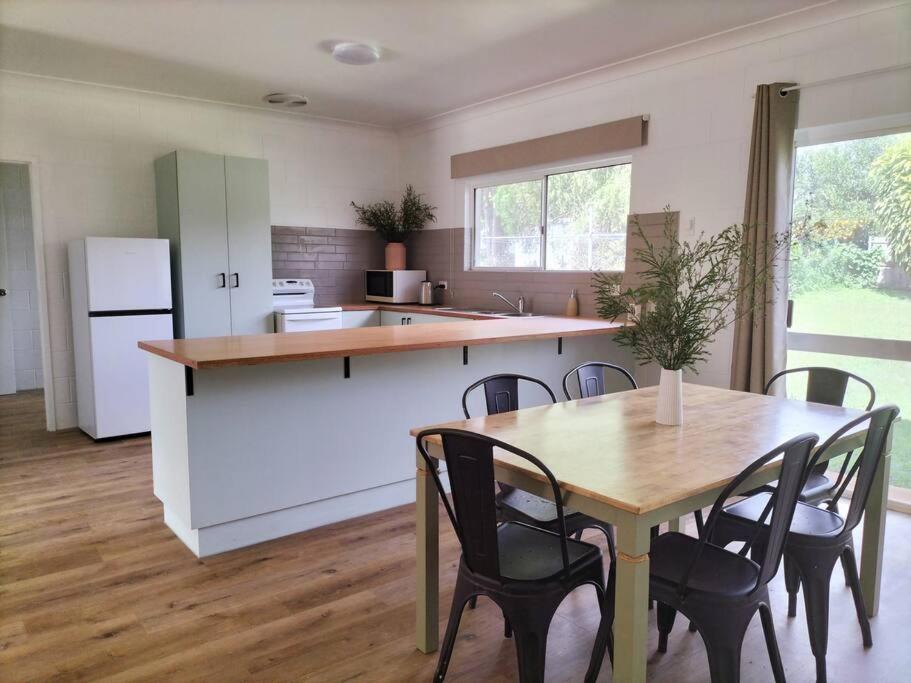 a kitchen with a table and chairs and a refrigerator at Spacious, Modern & Central in Atherton