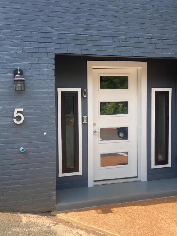a blue building with a white door and a number five at Sonsak - Unit 5 in Charlottesville