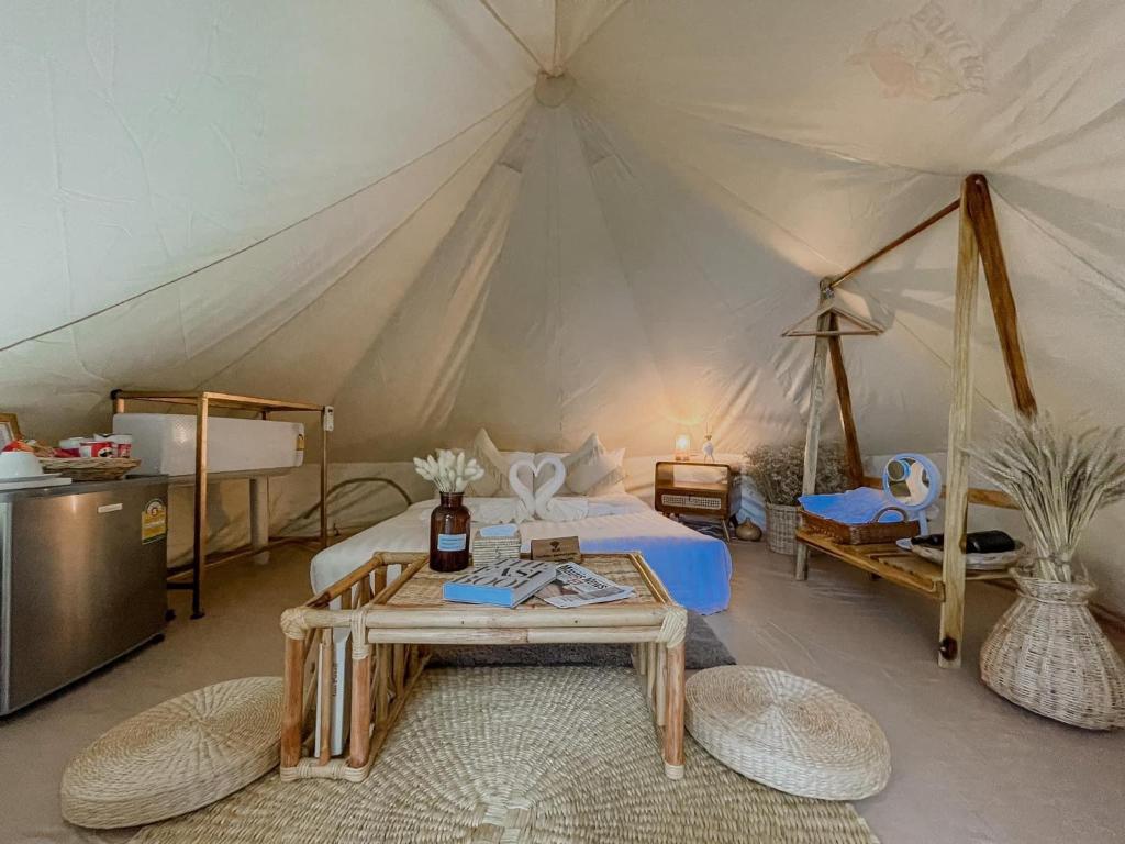 カタビーチにあるGreenheart garden View Camp phuketのベッド1台とテーブル付きのテントの部屋