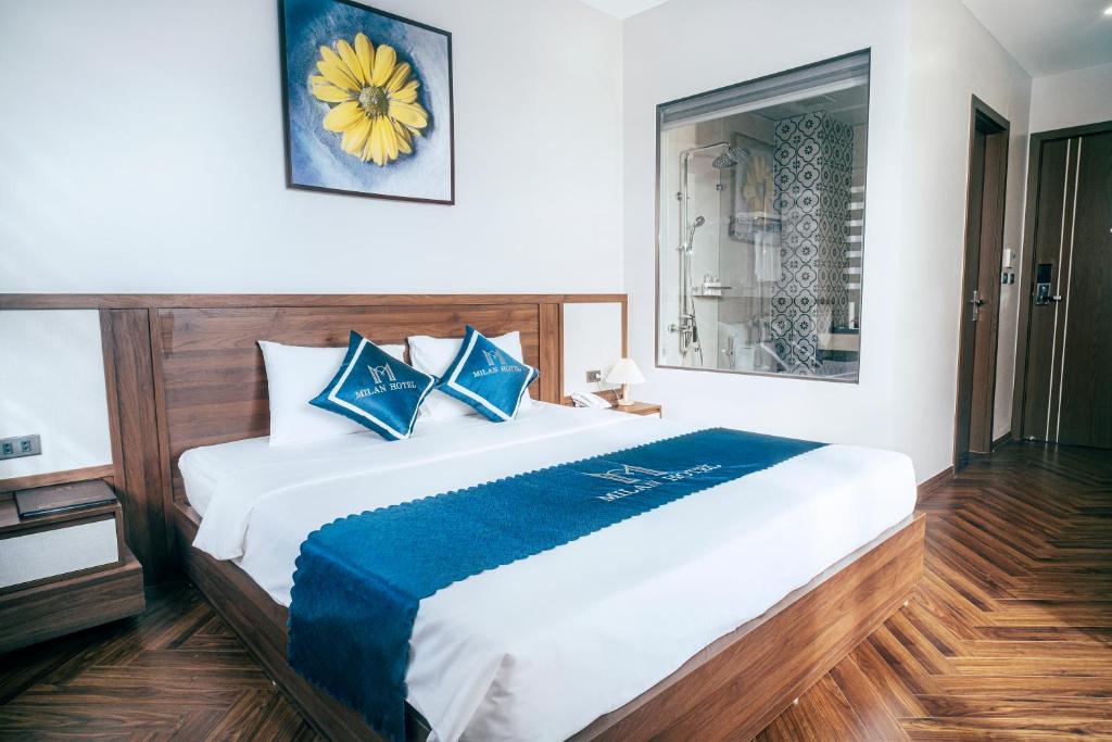 1 dormitorio con 1 cama grande con almohadas azules en Milan Hotel Ninh Bình en Ninh Binh