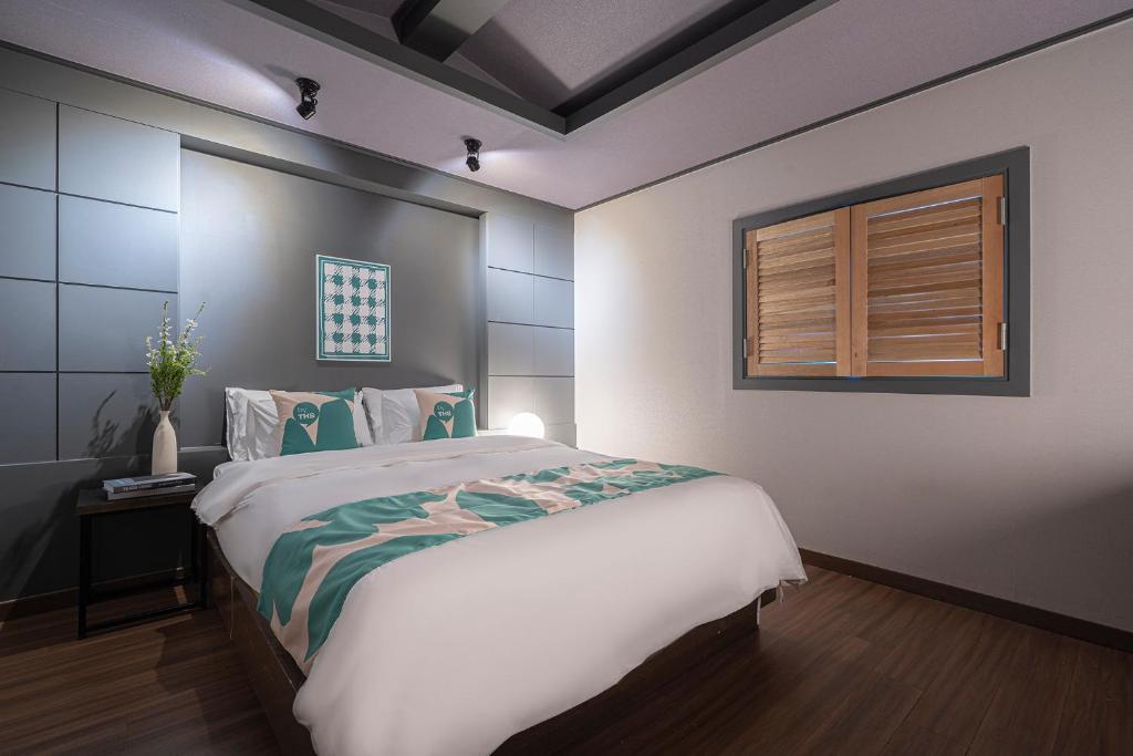 - une chambre avec un grand lit et une fenêtre dans l'établissement BY THS Valentine Hotel Incheon, à Siheung