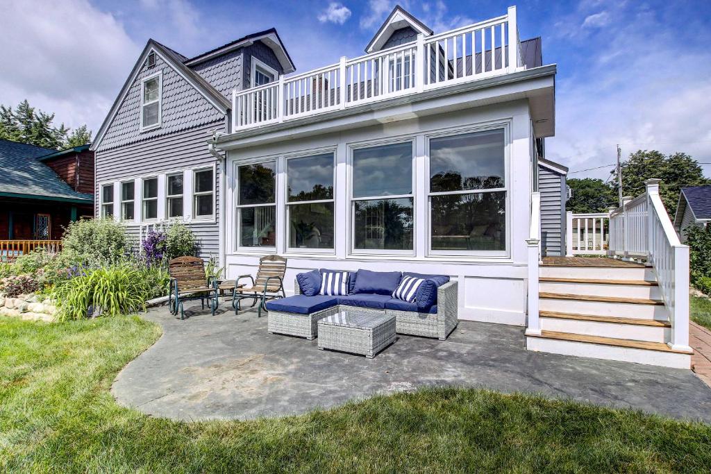 a house with a patio with a blue couch at NEW! Lake Winnebago Waterfront Retreat in Oshkosh