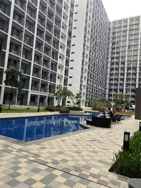 un grand immeuble avec une piscine en face de celui-ci dans l'établissement Shore 2 Tower 2 Staycation, à Manille