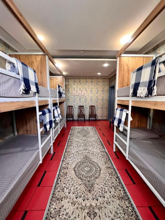 シムケントにあるInJoy hostelの赤いタイルフロアの客室で、二段ベッド4組が備わります。