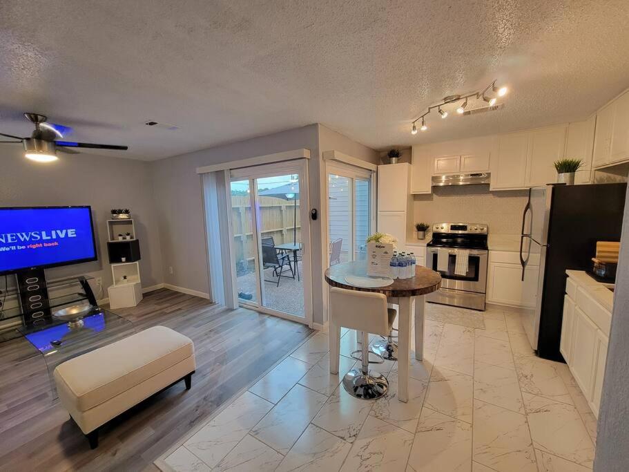 eine Küche und ein Wohnzimmer mit einem Tisch und einem TV in der Unterkunft Spacious n Cozy 3 Bedroom // 15 min from Downtown in Houston